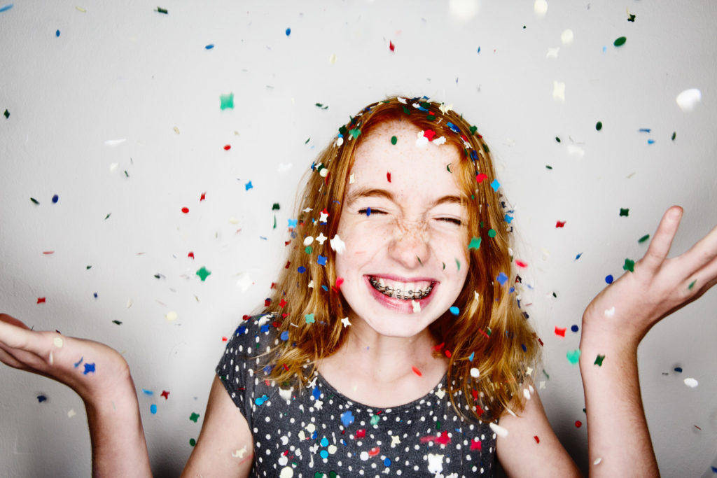 girl smiling with braces and confetti